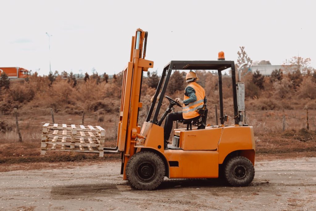 A worker in reflective gear operating a forklift outside in Ünye, Turkey.